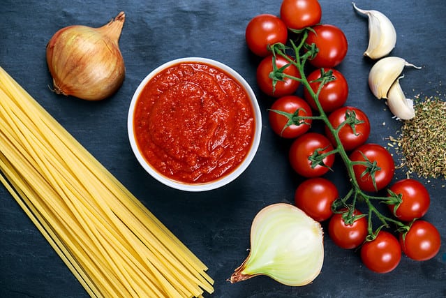 Ingredients for Spaghetti with marinara sauce. Ready to Cook. On blue background.